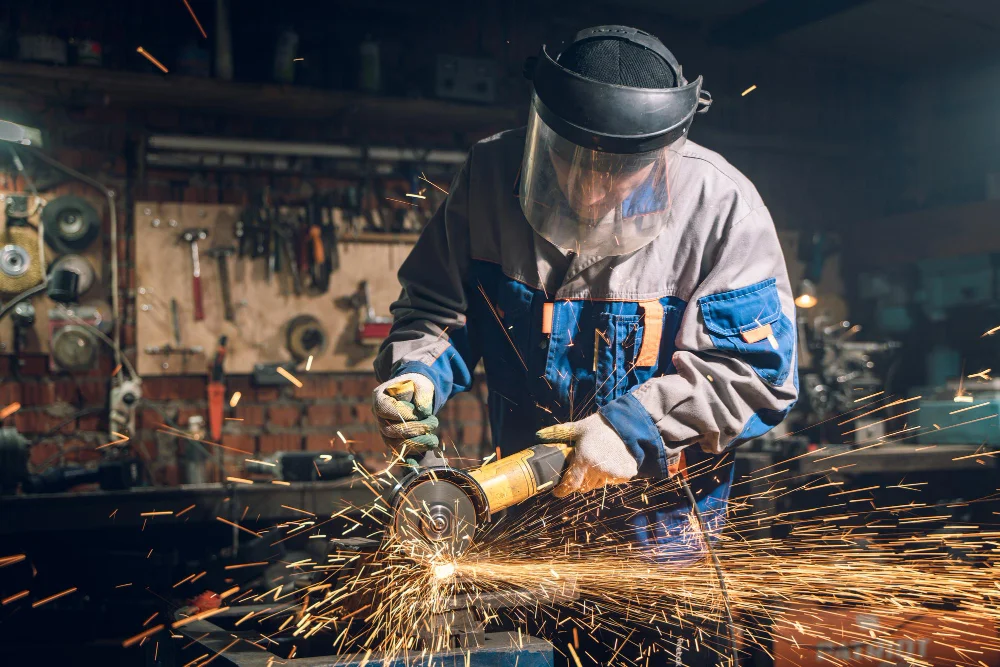 Serralheiro da Tub Ferro esmerilhando metal com faíscas em oficina industrial